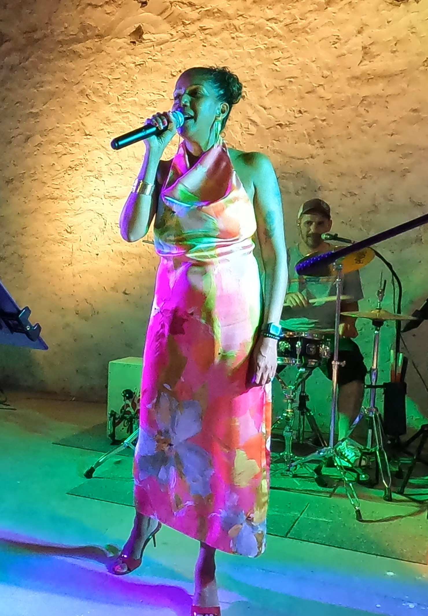 Esther au micro, robe noire, lumières orangées