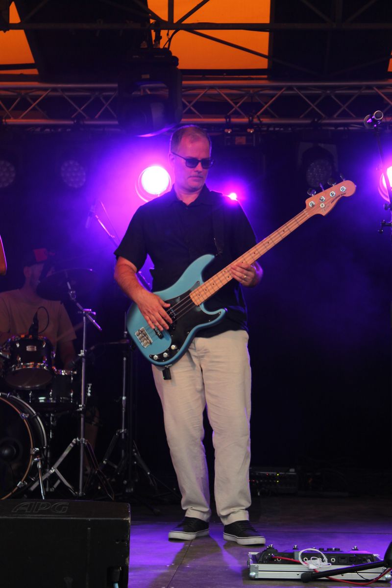 Stéphane à la basse sur scène, lumières violettes
